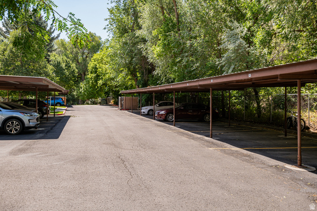 1221 Waterside Cove, Unit 11 Midvale, UT 84047 - Photo 18 of 23 Paved parking area featuring multiple covered carports with brown metal structures