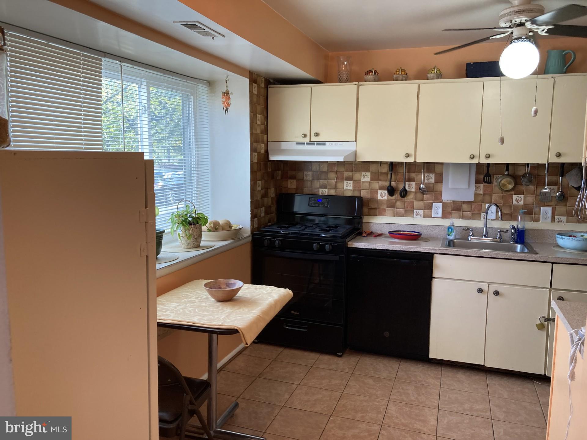2310 Sun Valley Circle, Unit 1D Silver Spring, MD 20906 - Photo 2 of 20 a kitchen with a sink cabinets and window