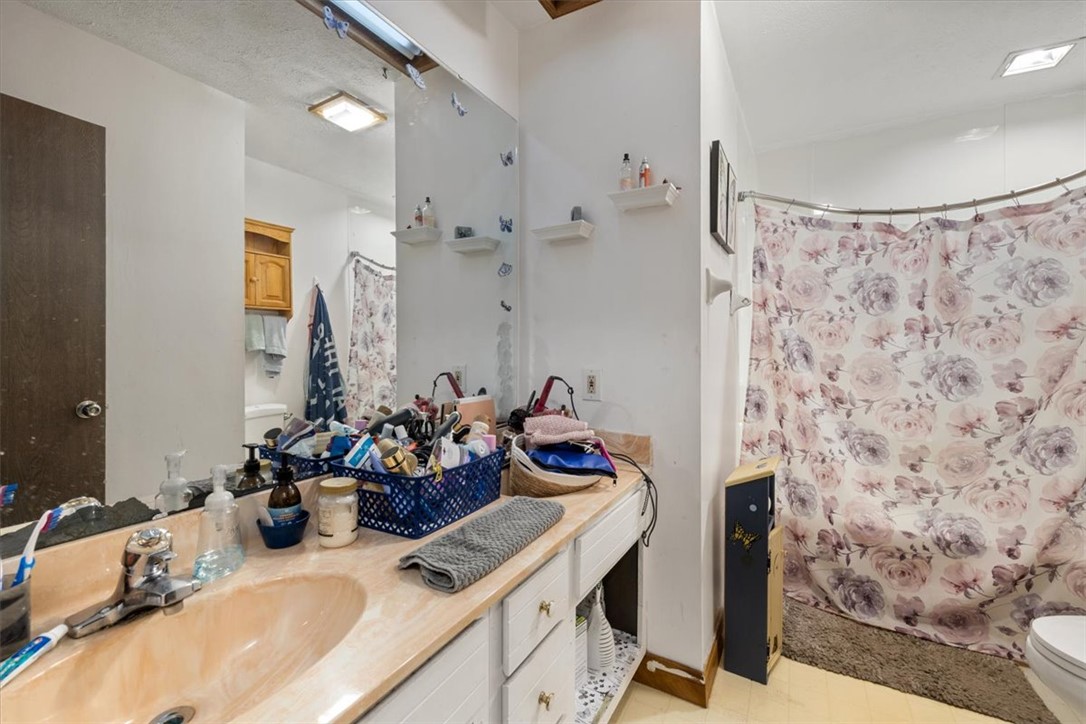 7225 Garber Road Clayton, OH 45415 - Photo 12 of 33 This bright bathroom features a spacious vanity with ample storage and a shower with a privacy curtain.