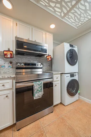 a kitchen with granite countertop a sink and white cabinets