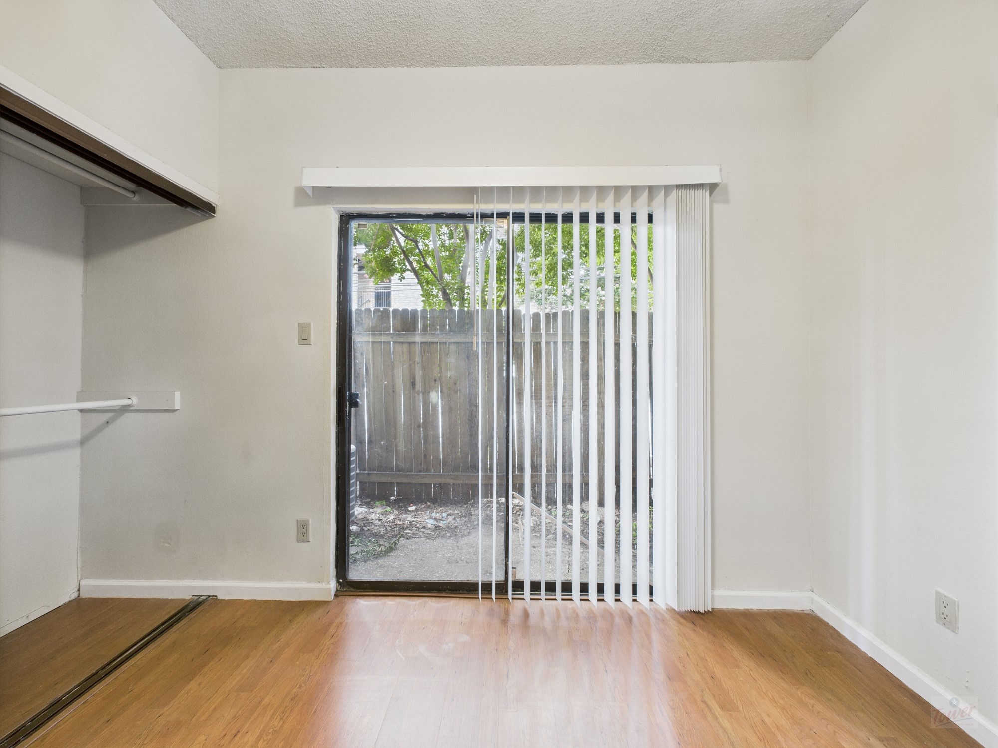 2815 Rio Grande Street, Unit 109 Austin, TX 78705 - Photo 14 of 25 an empty room with wooden floor and windows