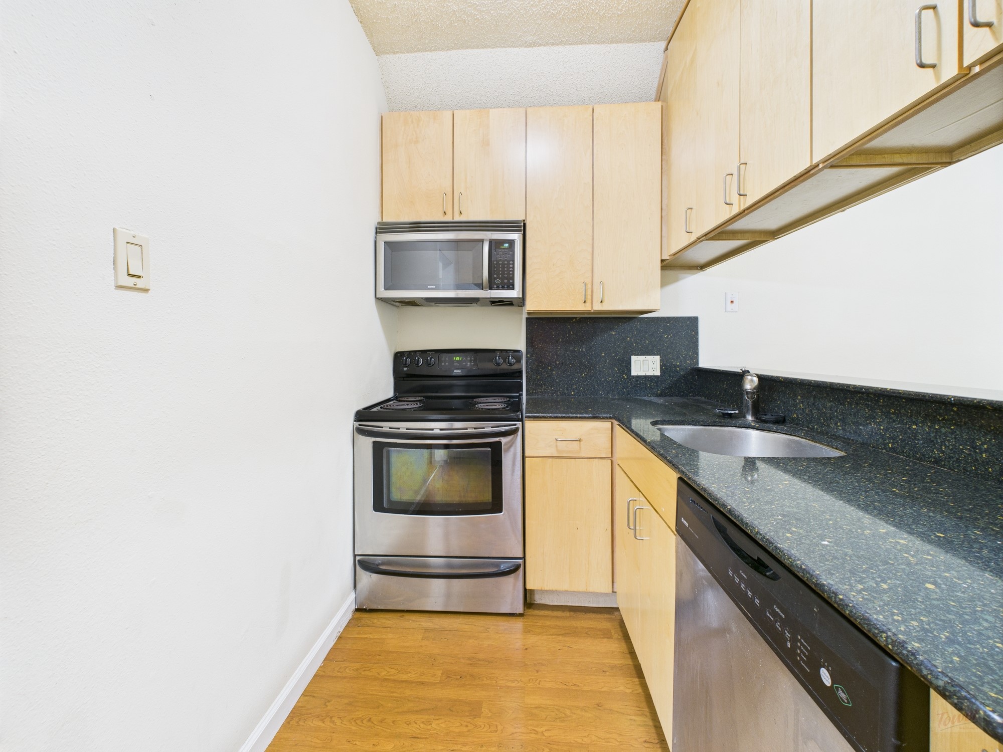 2815 Rio Grande Street, Unit 109 Austin, TX 78705 - Photo 2 of 25 a kitchen with stainless steel appliances granite countertop a sink and a stove