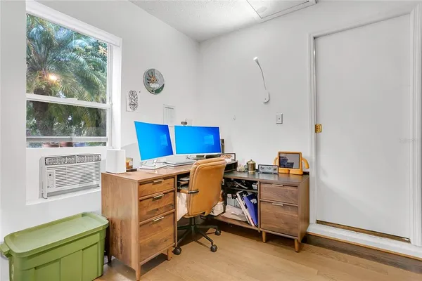 a view of a workspace with furniture and a window