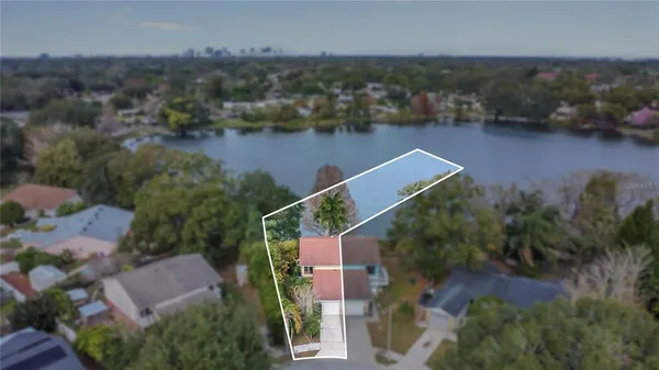 an aerial view of house with yard and lake view