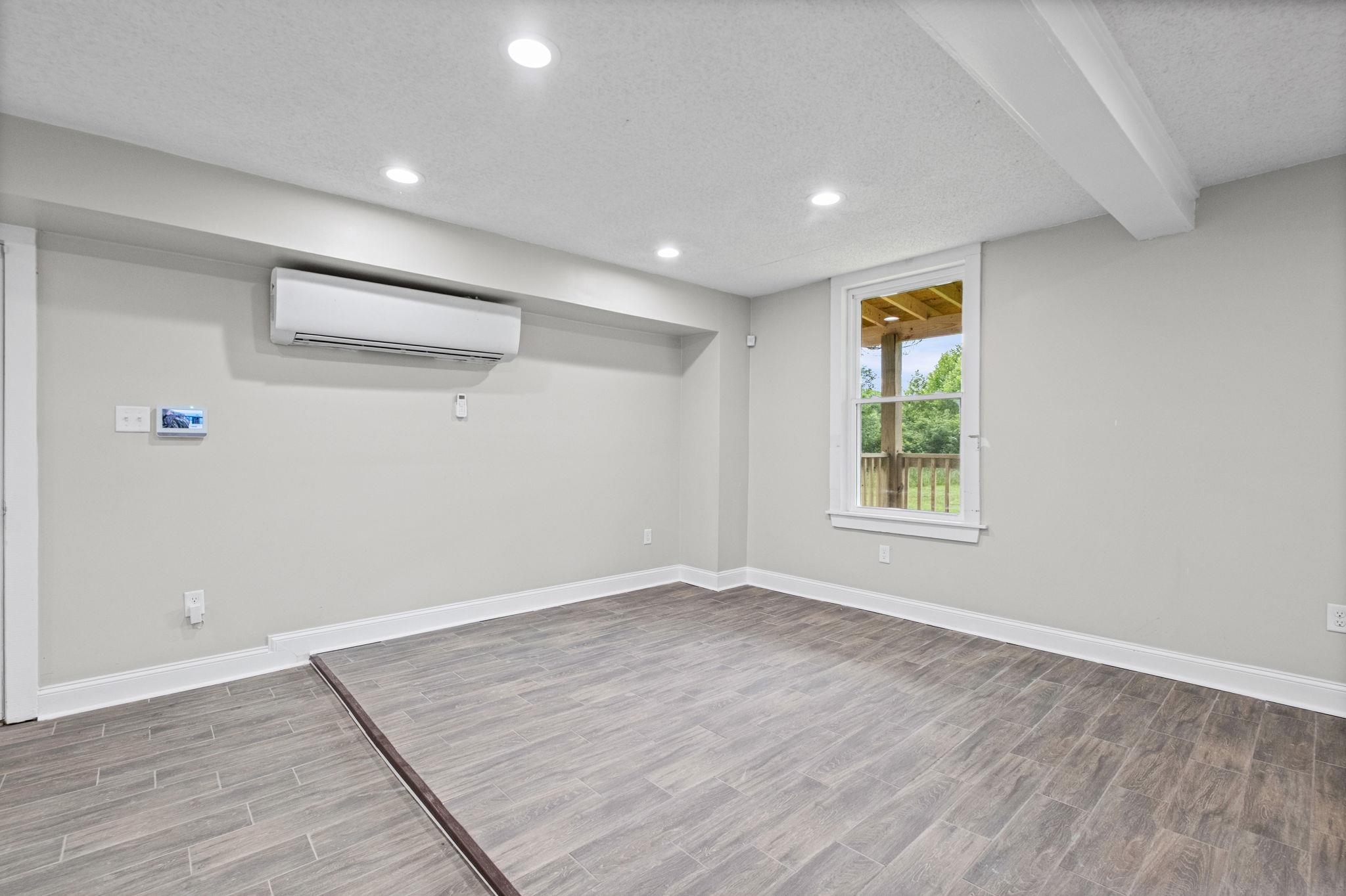 5843 Stewart Road Lakeland, TN 38002 - Photo 9 of 26 Spacious room featuring wood-finish tile flooring, recessed lighting, and a white-framed window