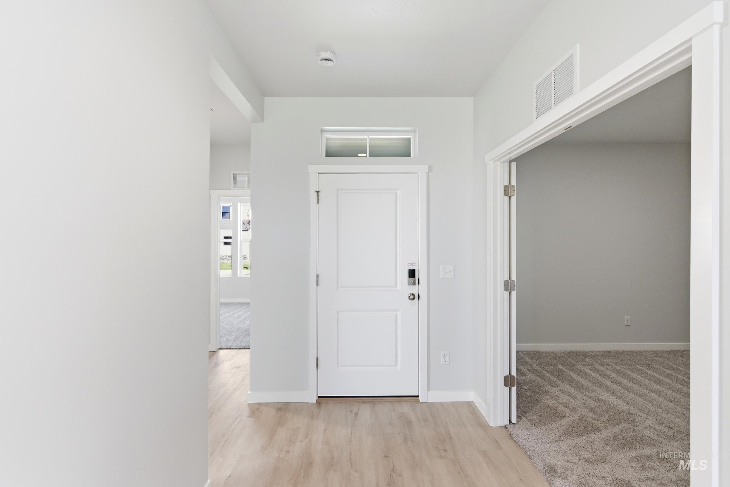13663 Redway Court Caldwell, ID 83607 - Photo 2 of 32 Entryway featuring wood-finish flooring, white paneled door with transom window, and neutral wall tones
