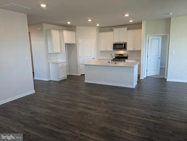 a kitchen with stainless steel appliances granite countertop a refrigerator sink and white cabinets