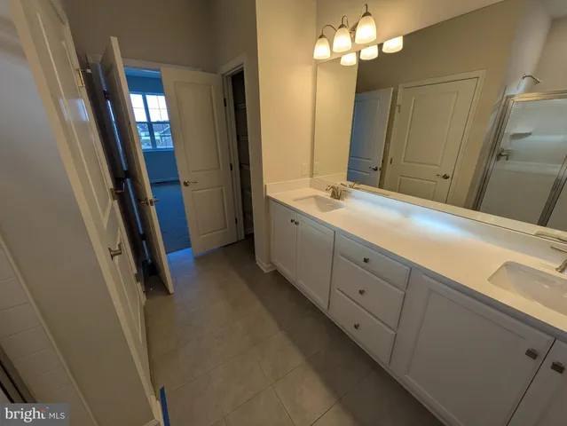 an empty room with chandelier fan and windows