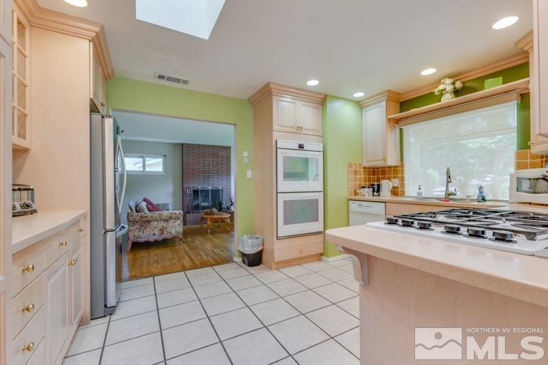 1870 Watt Street Reno, NV 89509 - Photo 8 of 26 a kitchen with stainless steel appliances granite countertop a stove and a view of living room