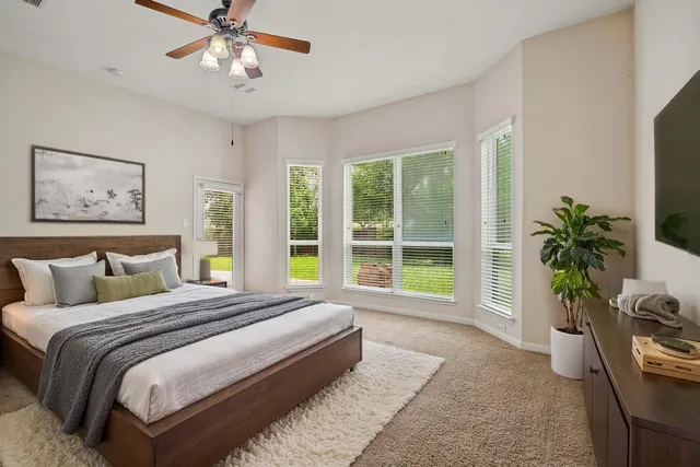 a spacious bedroom with a large bed and a large window