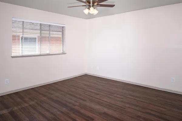 a view of a room with wooden floor and a ceiling fan