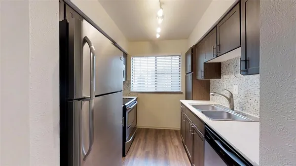 a kitchen with a refrigerator a sink and cabinets