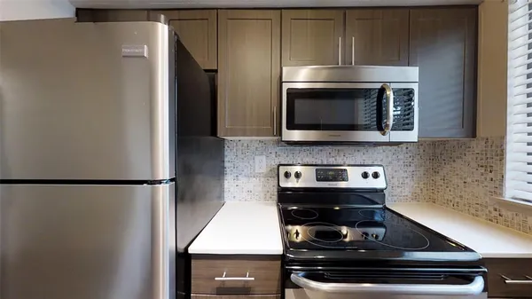 a kitchen with a refrigerator and a stove