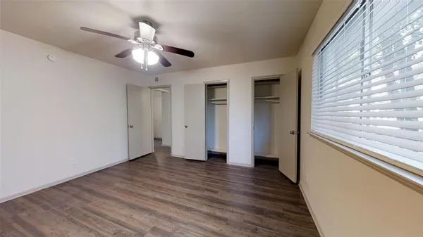 a view of a hallway with wooden floor and chandelier