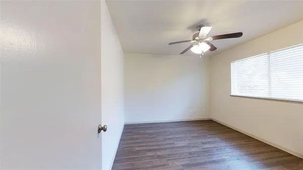 a view of a room with wooden floor and fan