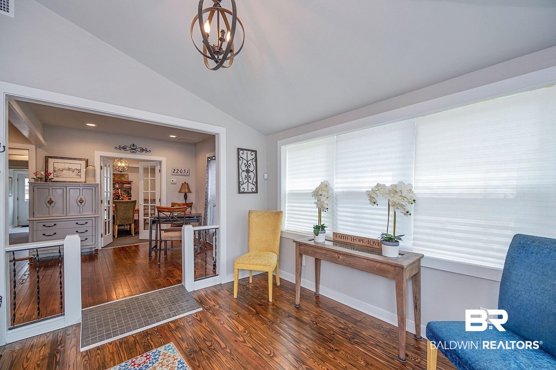 22051 Broad Street Silverhill, AL 36576 - Photo 6 of 28 Living area with vaulted ceiling, a chandelier, and dark hardwood / wood-style flooring