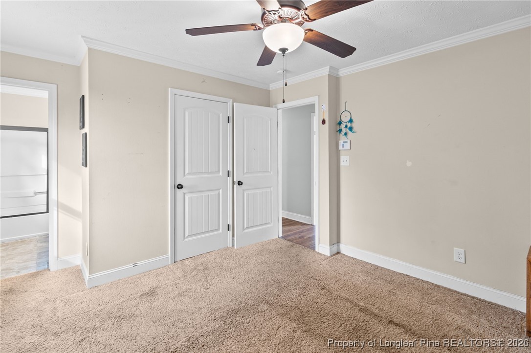 6654 Vaughn Road Fayetteville, NC 28304 - Photo 22 of 36 an empty room with closet and a chandelier fan