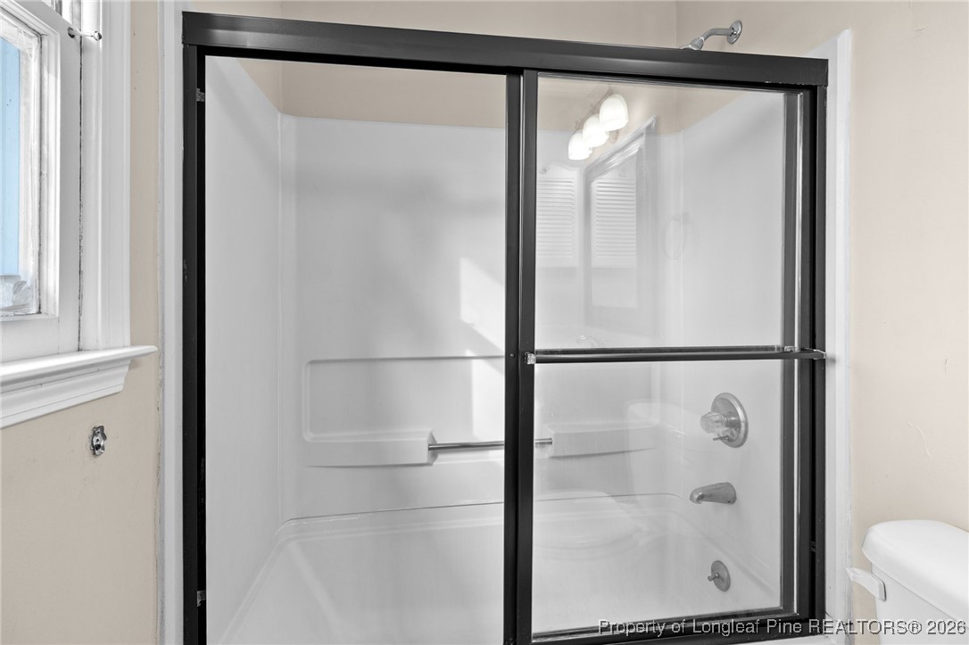 6654 Vaughn Road Fayetteville, NC 28304 - Photo 24 of 36 a bathroom with a glass shower door
