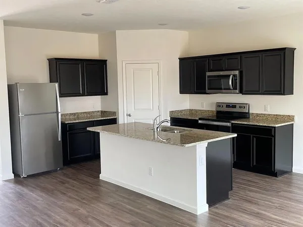 a kitchen with a refrigerator and a stove