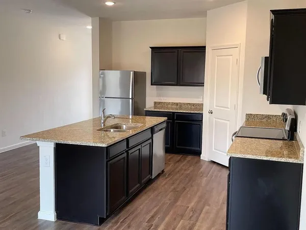 a kitchen with stainless steel appliances granite countertop a sink stove and refrigerator