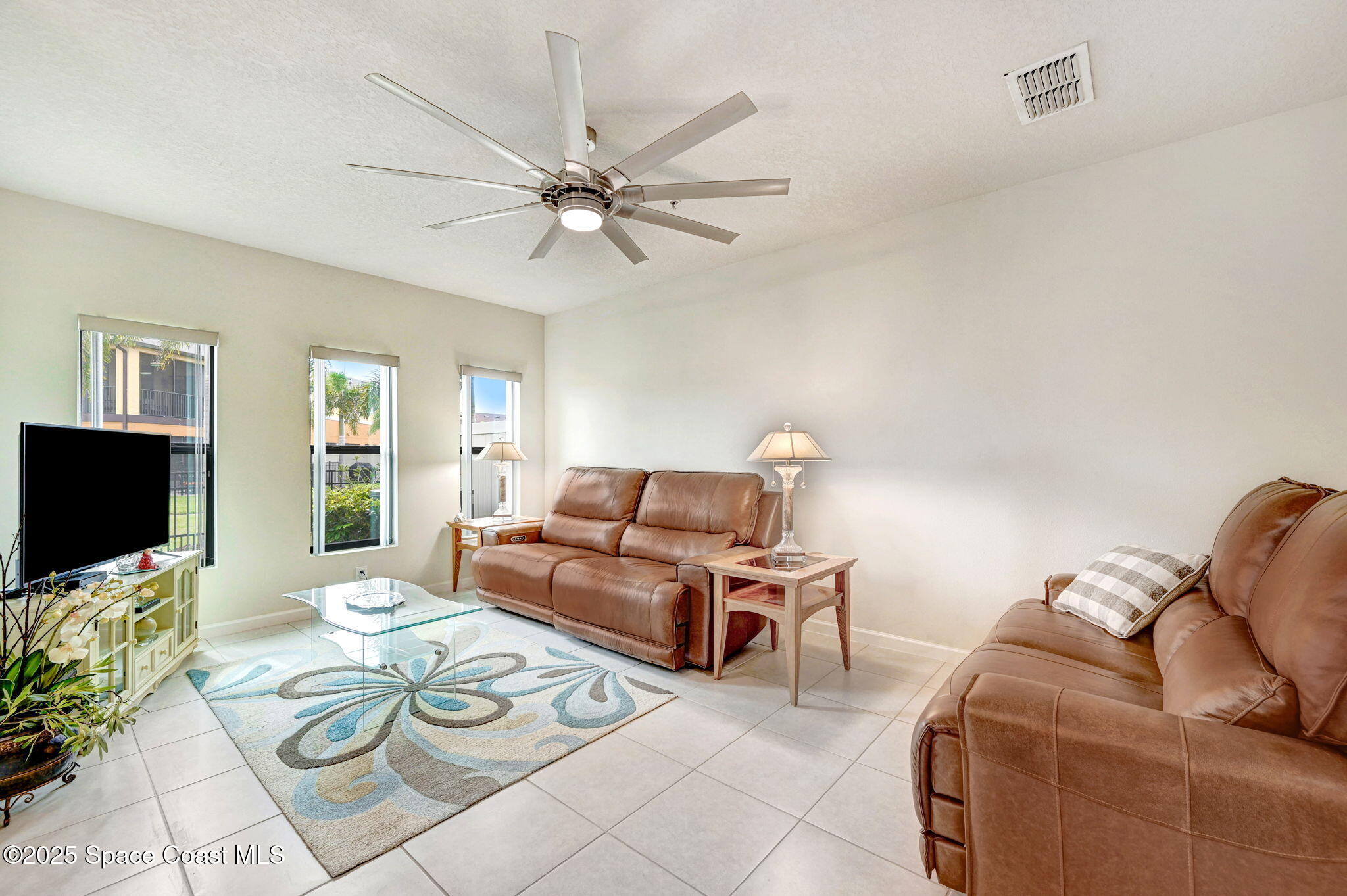 1430 Lara Circle, Unit 103 Rockledge, FL 32955 - Photo 15 of 39 a living room with furniture a flat screen tv and a window