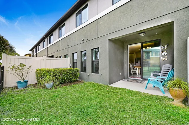 a view of a chair and table in backyard of the house