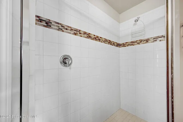 a bathroom with a shower a mirror and shower