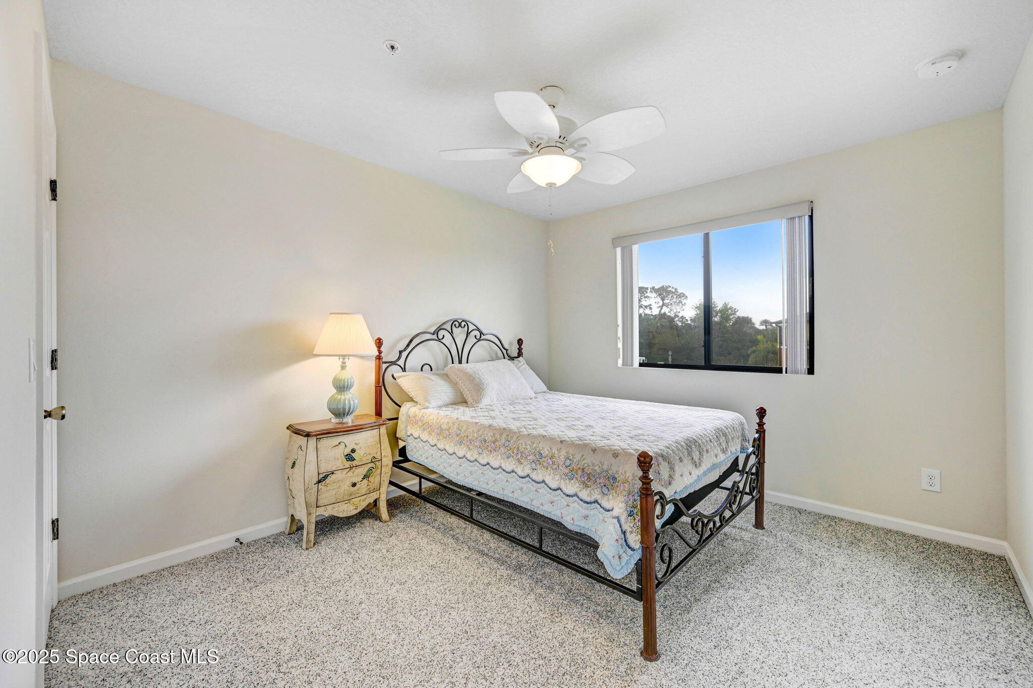 1430 Lara Circle, Unit 103 Rockledge, FL 32955 - Photo 29 of 39 a bed sitting in a room next to a lamp