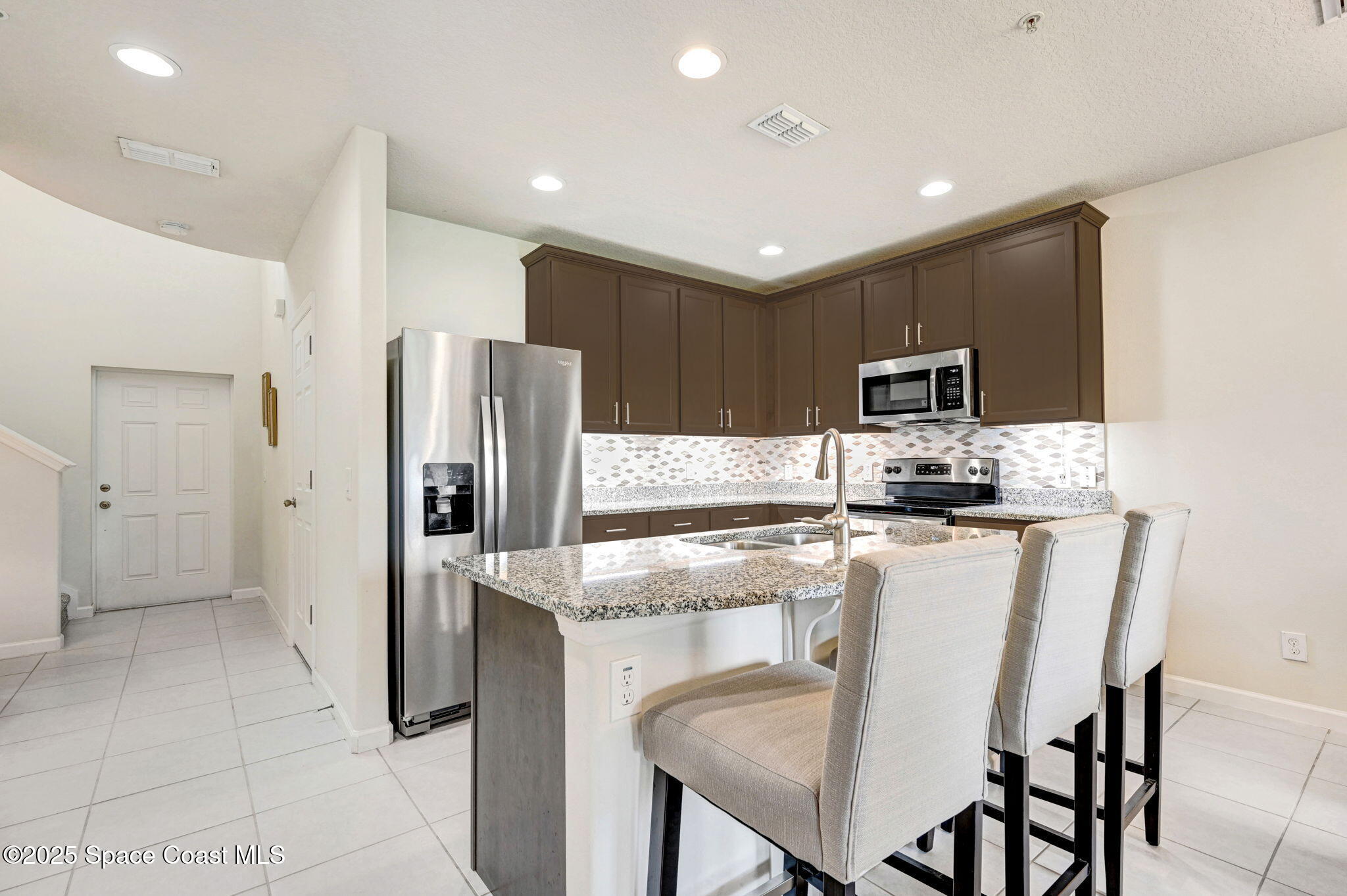1430 Lara Circle, Unit 103 Rockledge, FL 32955 - Photo 6 of 39 a kitchen with stainless steel appliances a refrigerator stove microwave and cabinets