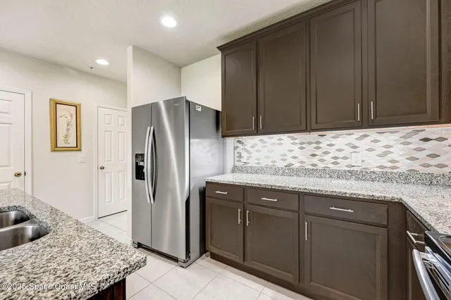 a kitchen with stainless steel appliances granite countertop a refrigerator and a sink