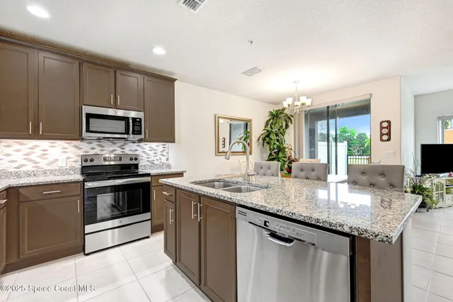 a kitchen with granite countertop stainless steel appliances a stove sink microwave and cabinets