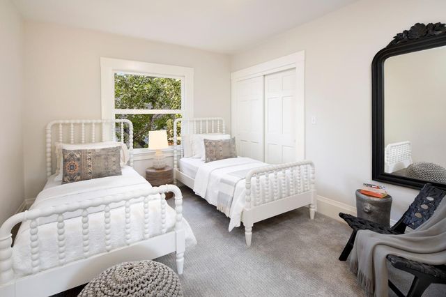 a bedroom with two beds and a window