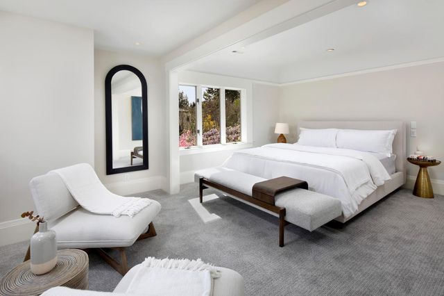 a bedroom with bed and a large window