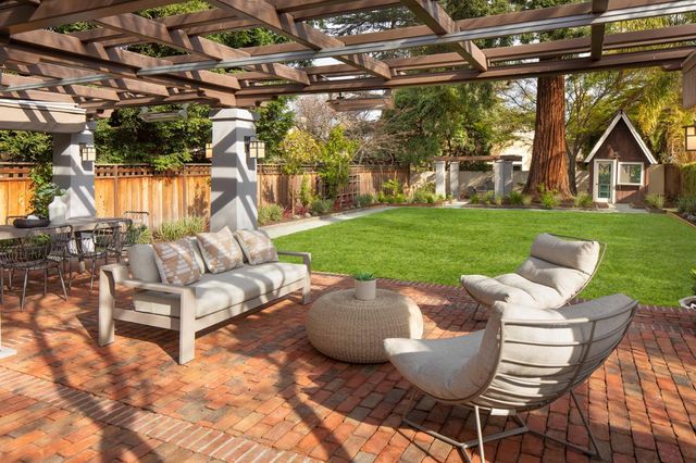 a roof deck with table and chairs and a barbeque