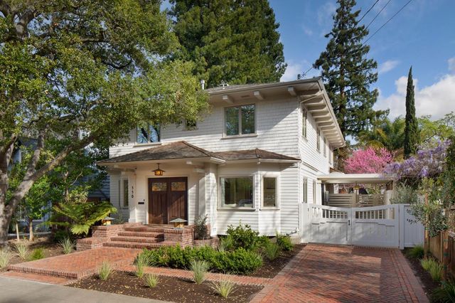 a view of a white house with a small yard and a large tree