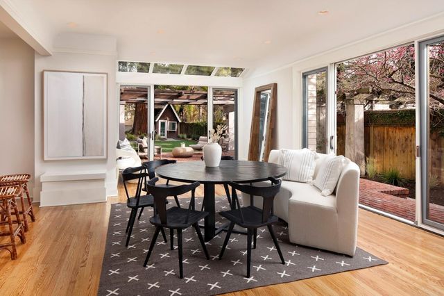 a view of a dining room with furniture wooden floor and a floor to ceiling window