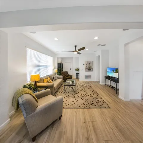 a living room with furniture and a wooden floor