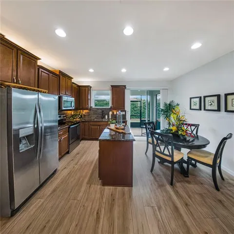 a kitchen with stainless steel appliances wooden floors and wooden cabinets