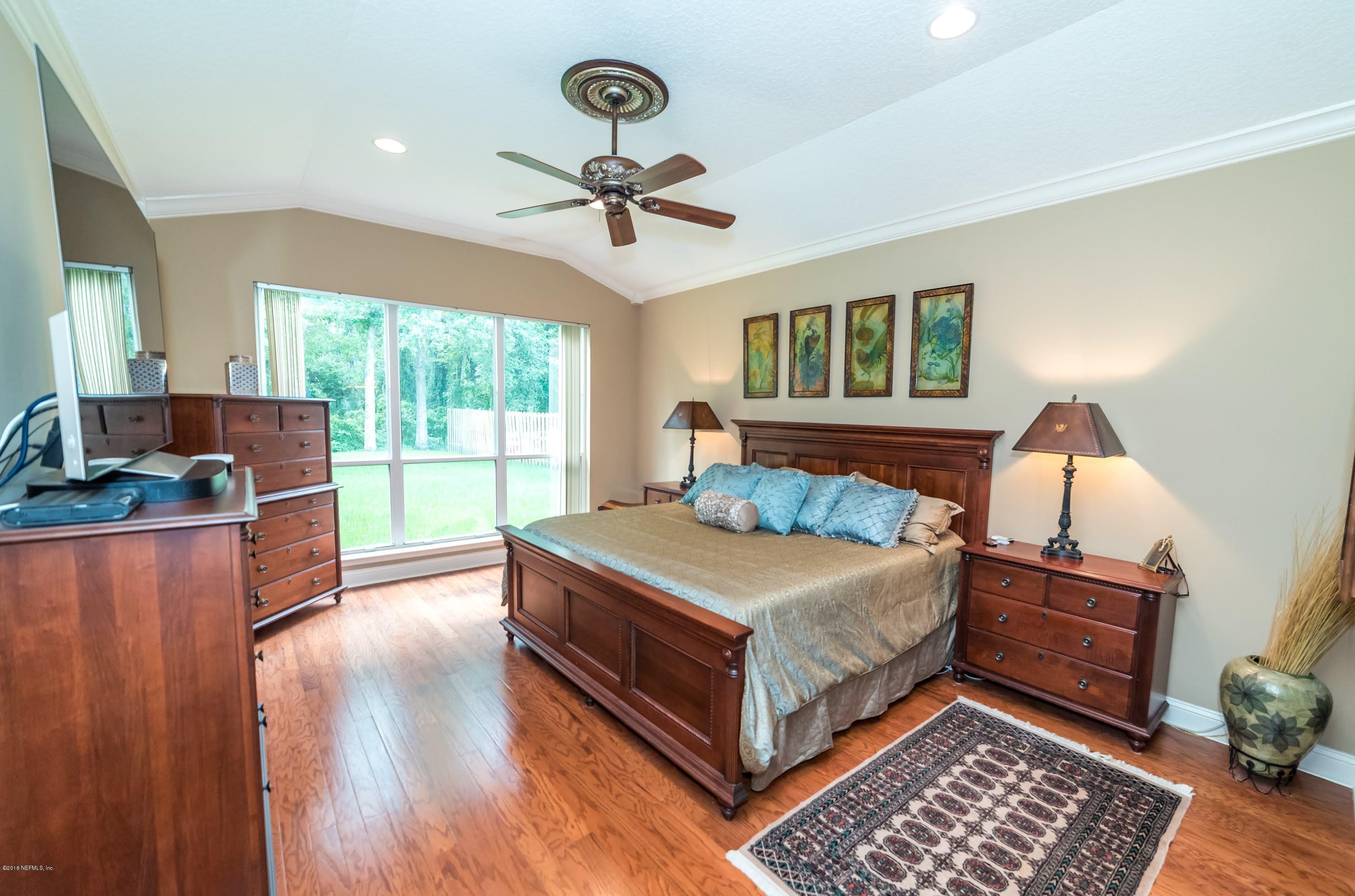 8964 Timberjack Lane Jacksonville, FL 32256 - Photo 13 of 23 a bedroom with a bed and a chandelier