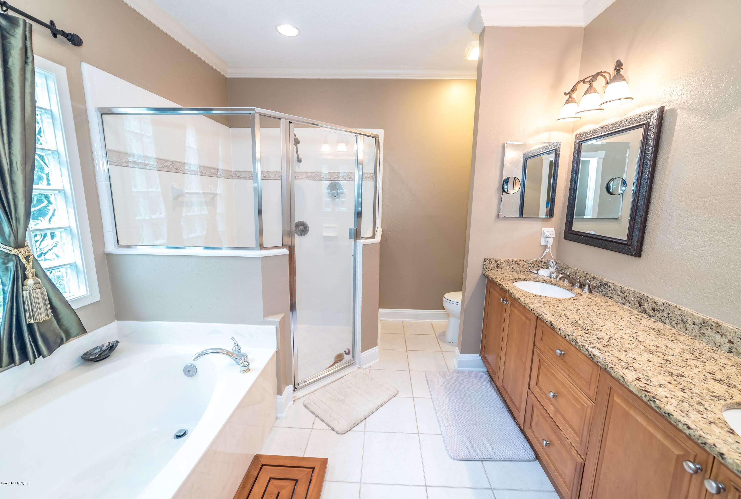8964 Timberjack Lane Jacksonville, FL 32256 - Photo 15 of 23 a spacious bathroom with a tub sink and mirror
