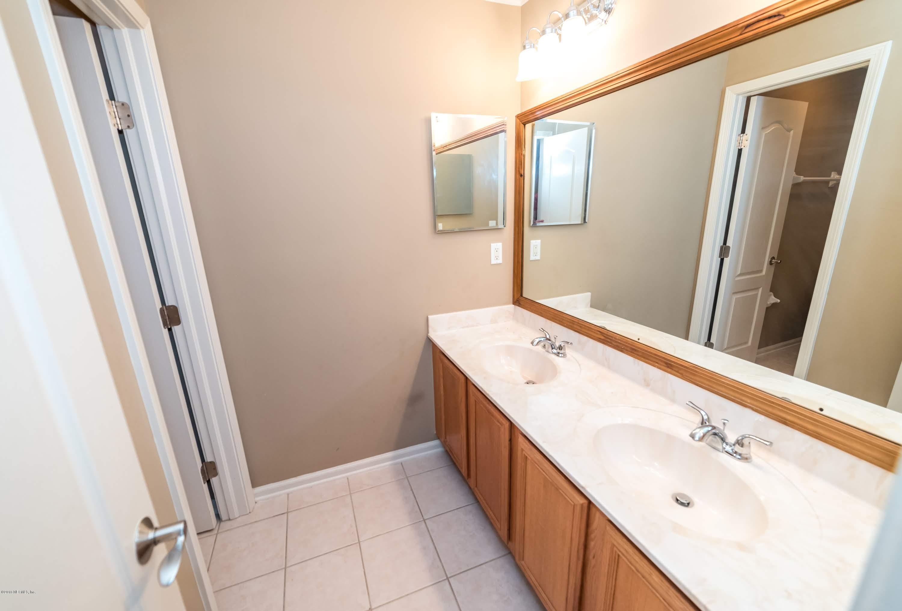 8964 Timberjack Lane Jacksonville, FL 32256 - Photo 18 of 23 a bathroom with a double vanity sink and mirror