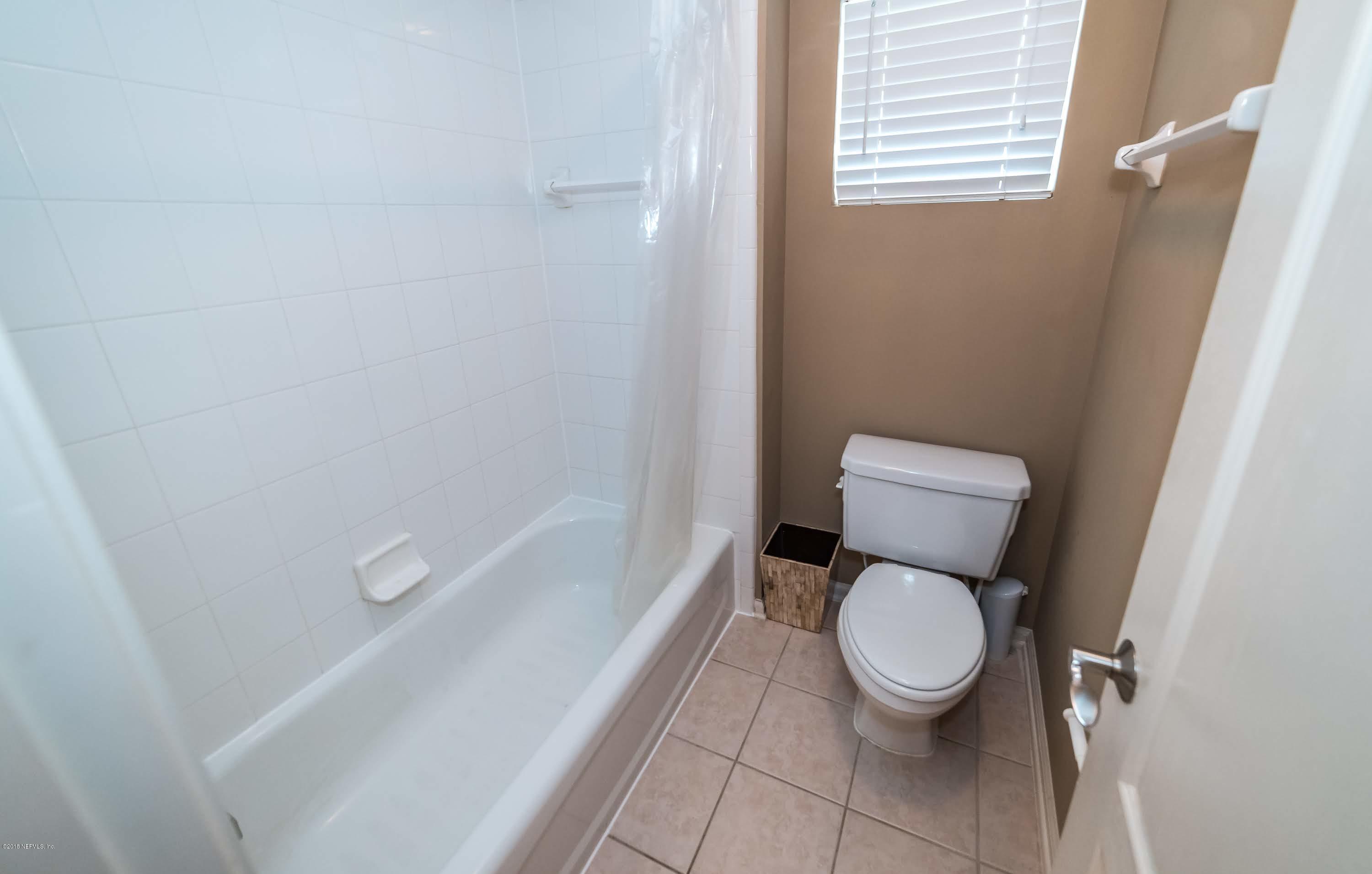 8964 Timberjack Lane Jacksonville, FL 32256 - Photo 19 of 23 a white toilet sitting next to a bath tub