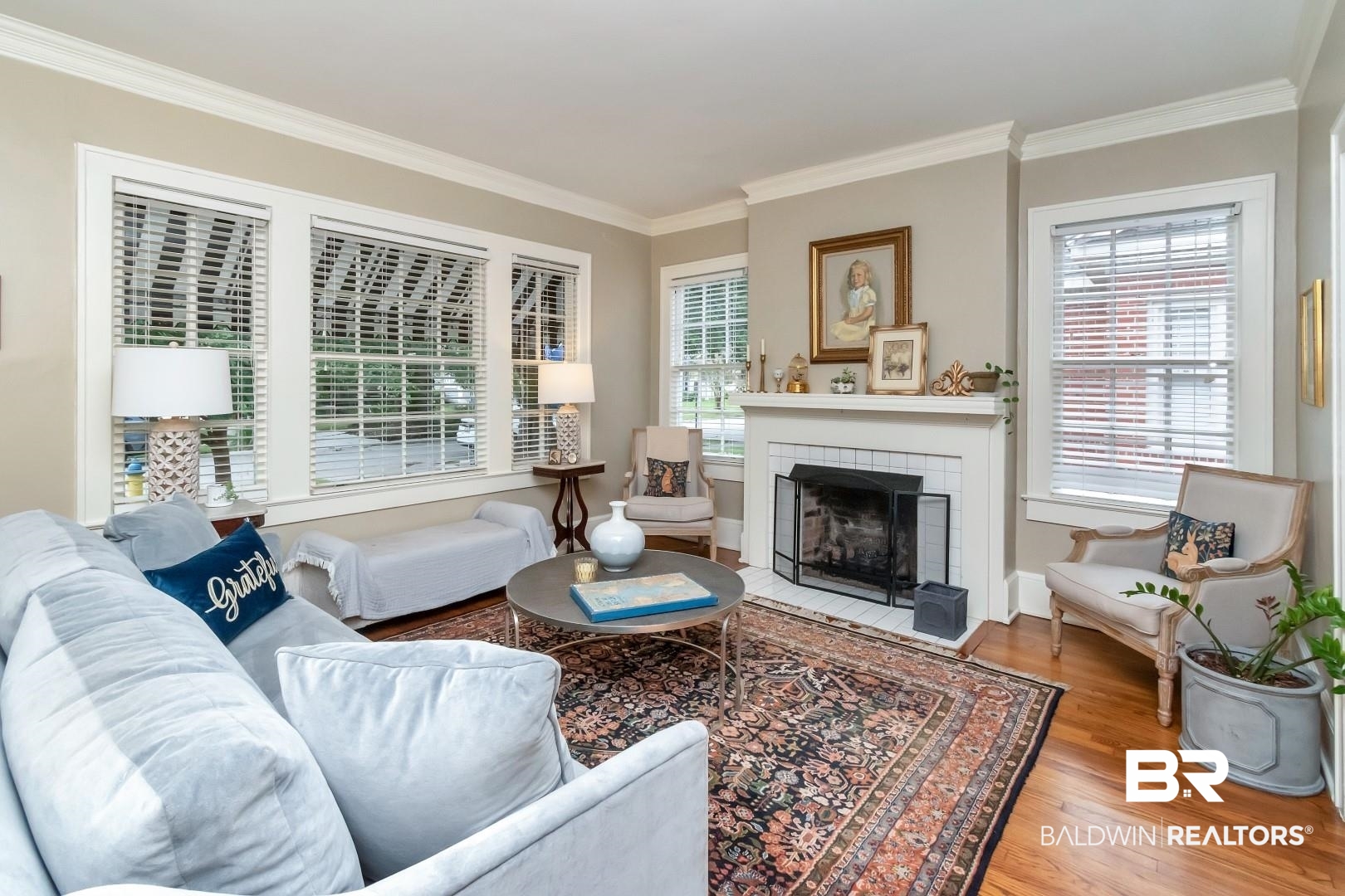 128 Silverwood Street Mobile, AL 36607 - Photo 2 of 34 Living room featuring crown molding, a wealth of natural light, wood-type flooring, and a tile fireplace