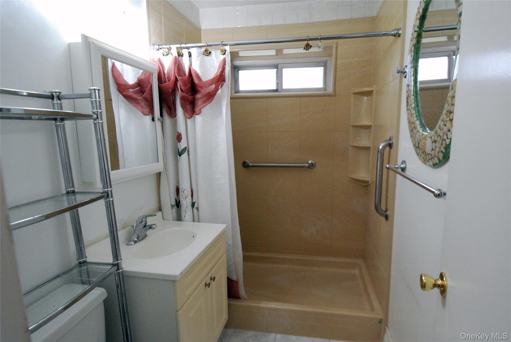 1523 Central Park Avenue, Unit 5F Yonkers, NY 10710 - Photo 15 of 20 a bathroom with a sink a mirror and a shower