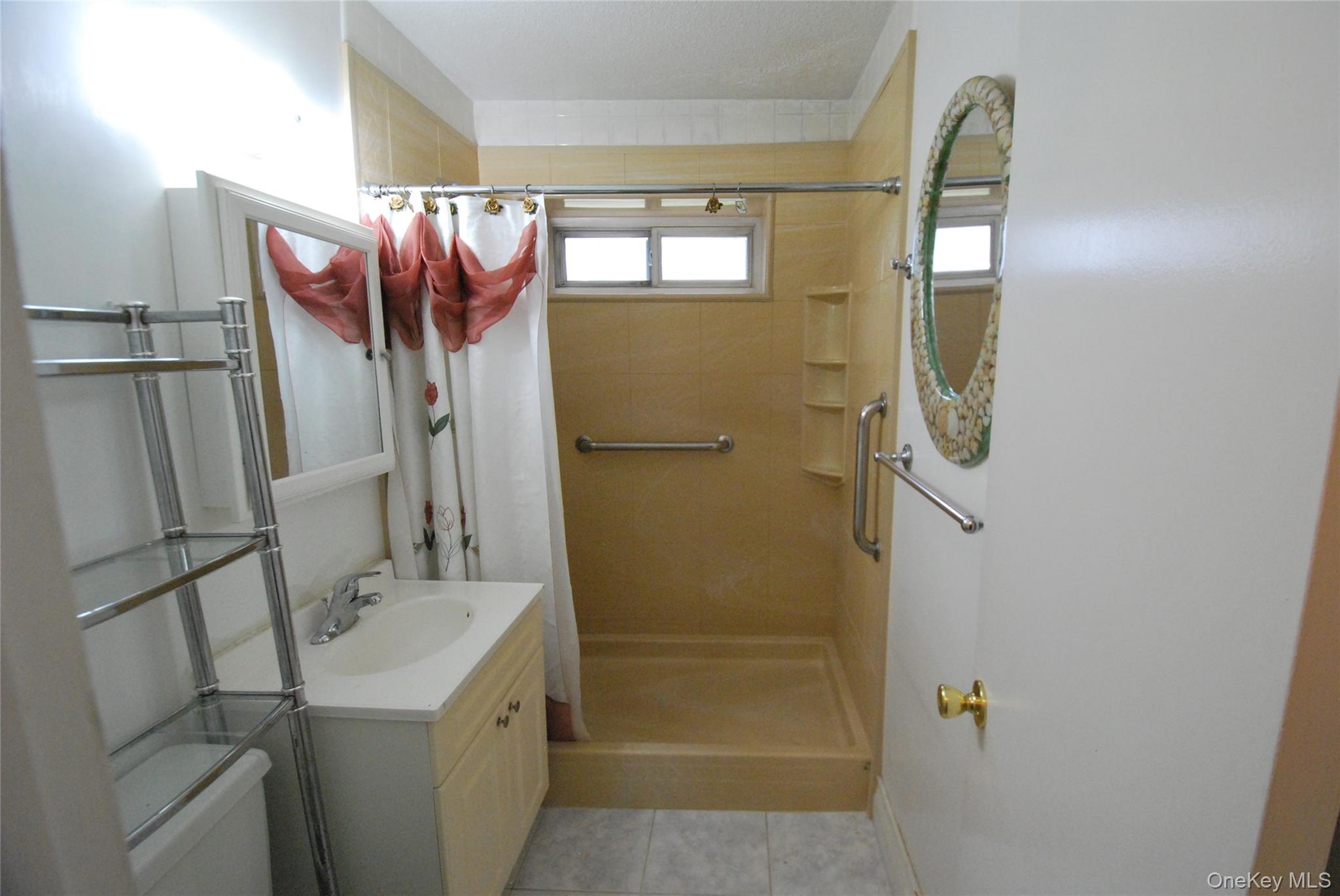 1523 Central Park Avenue, Unit 5F Yonkers, NY 10710 - Photo 16 of 20 a bathroom with a granite countertop shower a sink and a mirror
