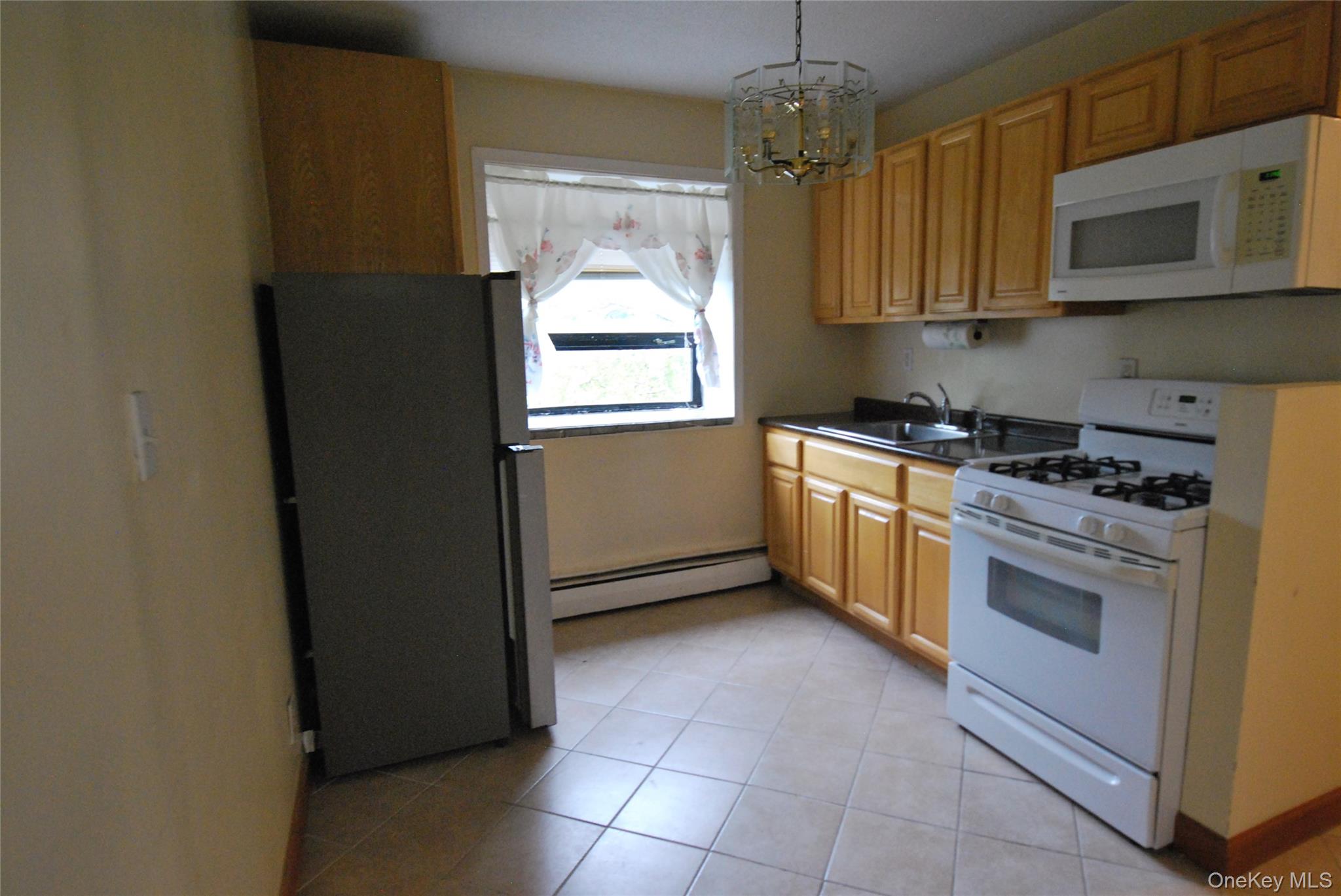 1523 Central Park Avenue, Unit 5F Yonkers, NY 10710 - Photo 3 of 20 a kitchen with stainless steel appliances granite countertop a stove a refrigerator and a microwave