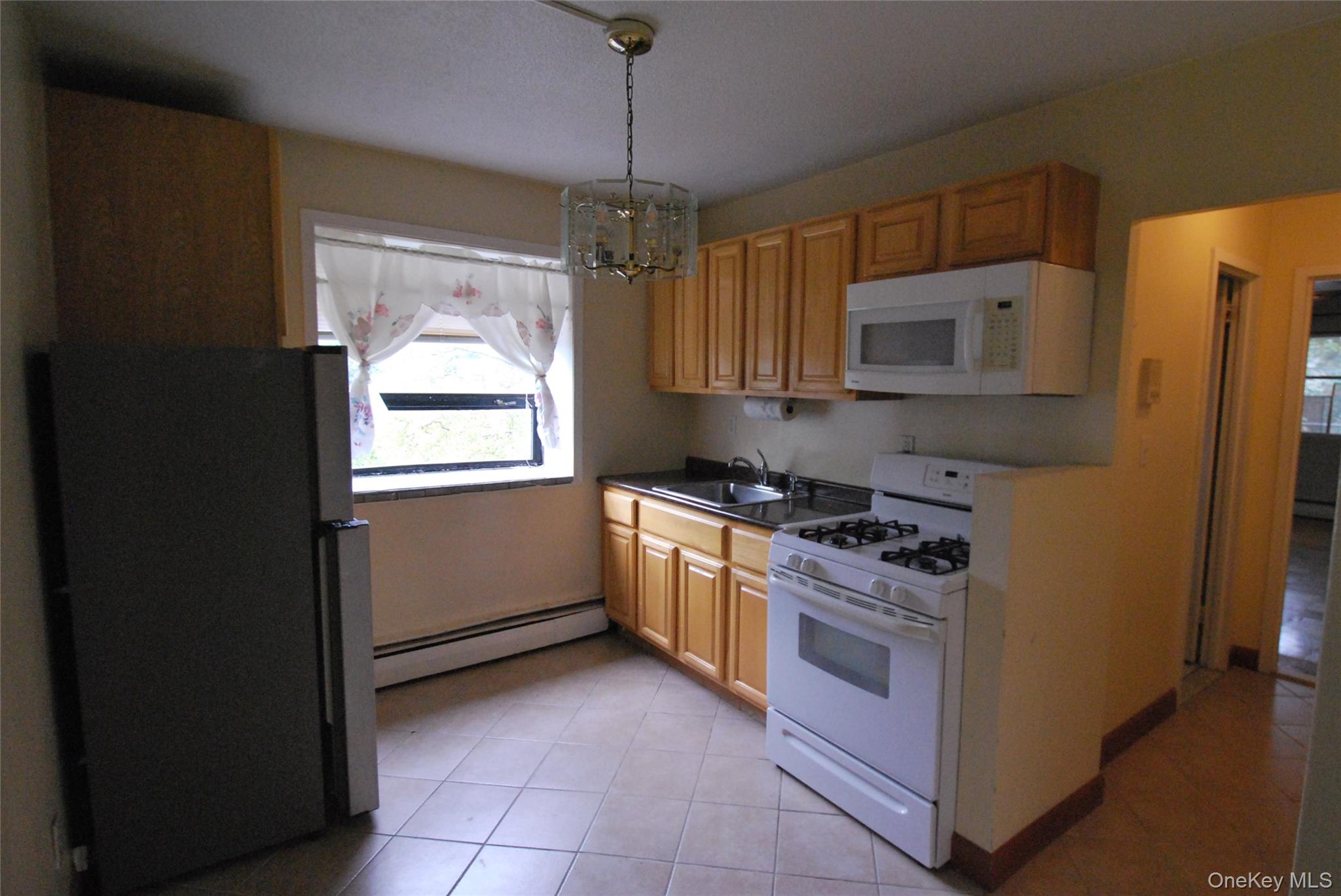 1523 Central Park Avenue, Unit 5F Yonkers, NY 10710 - Photo 5 of 20 a kitchen with a stove a sink and a refrigerator