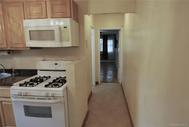 a kitchen with white cabinets and white appliances