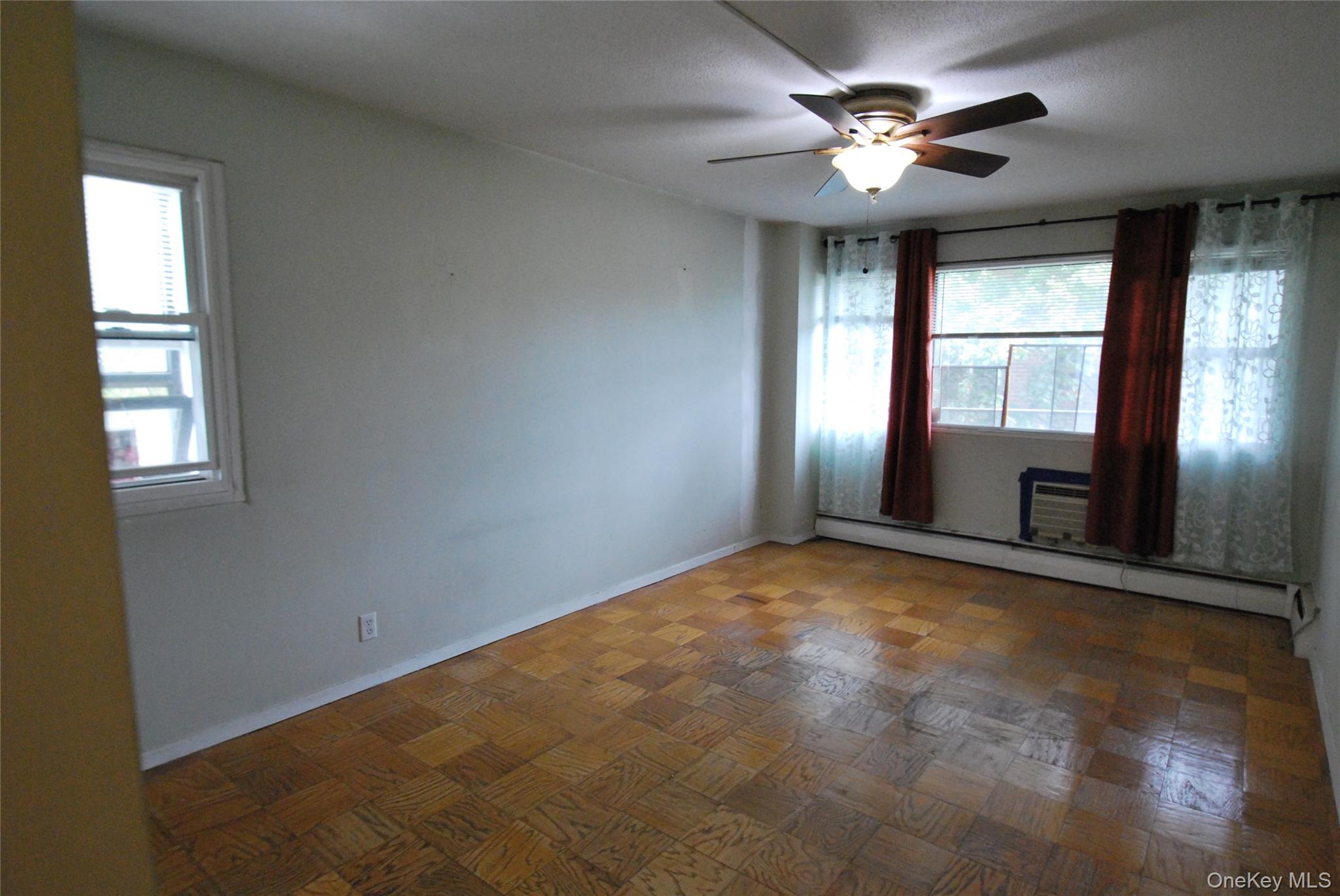 1523 Central Park Avenue, Unit 5F Yonkers, NY 10710 - Photo 9 of 20 an empty room with windows and chandelier fan