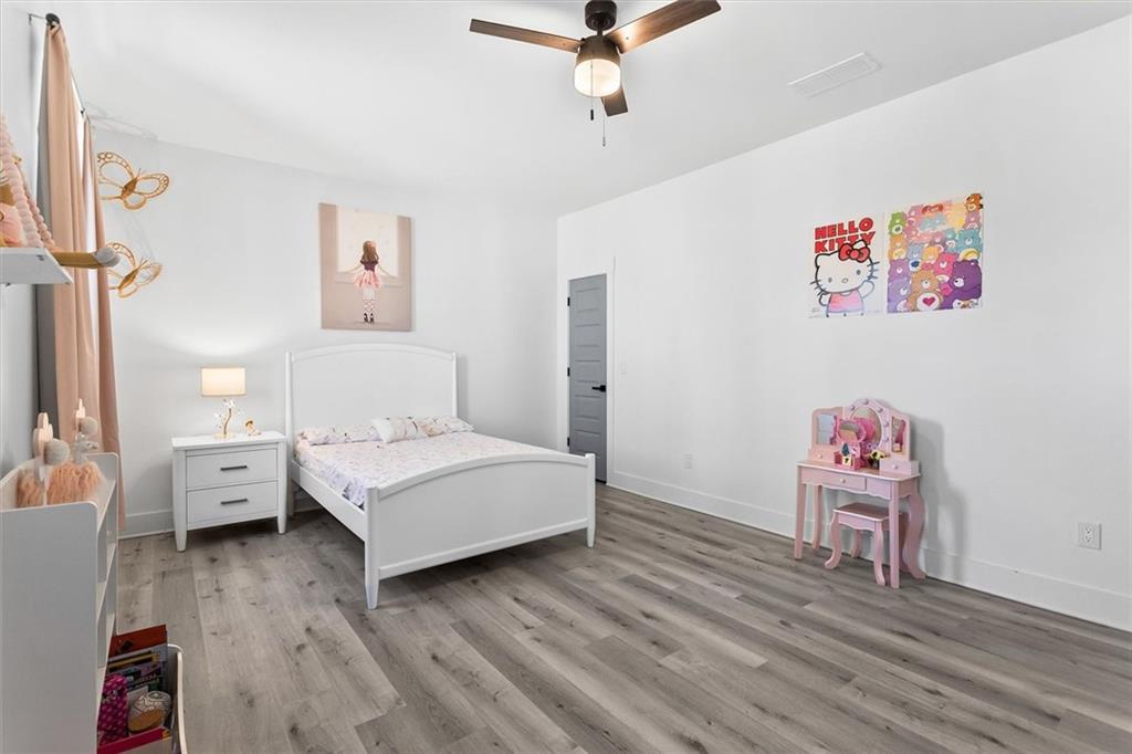 658 Rockbridge Road Northwest Lilburn, GA 30047 - Photo 23 of 61 a bedroom with a bed and wooden floor